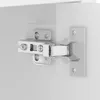 A close-up view of a cabinet hinge attached to a white surface. Náhled obrázku produktu