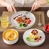 A person is eating a meal consisting of steak, soup, and dessert, with a glass of water and strawberries on the side. Voir les images du produit
