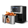 A silver and black air fryer with a basket full of fried chicken wings. Voir les images du produit