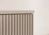 A close-up view of the top corner of a cabinet with a fluted front and a flat top. Náhled obrázku produktu