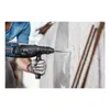A person is using a Bosch rotary hammer drill to drill into a concrete wall. Podgląd zdjęcia produktu