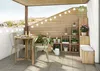 A balcony with a small table and chairs, plants, and storage shelves. Podgląd zdjęcia produktu