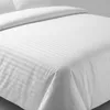A close-up view of white hotel bedding with a striped pattern. Produktbild-Vorschau