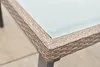 A close-up view of the corner of a table with a wicker-like frame and a frosted glass top. Produktbild-Vorschau