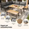 An outdoor patio furniture set, including a sectional sofa, coffee table, and bench, arranged on a rug with decorative plants in the background. Podgląd zdjęcia produktu