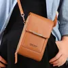 A person wearing a blue shirt and black top, holding a brown crossbody bag. Produktbild-Vorschau