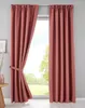 Two pink curtains are shown hanging in front of a window, with one curtain tied back with a fabric band.
