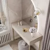 A vanity table with a mirror and accessories in a room. Produktbild-Vorschau