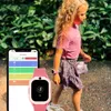 A young girl wearing a pink smartwatch walks outdoors, with a smartphone displaying health data next to her. Produktbild-Vorschau