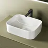 A white ceramic vessel sink with a black faucet is shown on a light green countertop. Produktbild-Vorschau