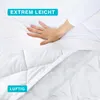 A hand pressing down on a white quilted blanket, with text overlays highlighting features. Produktbild-Vorschau