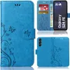 A collage of images showing a blue flip phone case with a floral and butterfly design, including views of the case open and closed, and a depiction of a phone inside. Produktbild-Vorschau