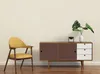 A yellow armchair and a brown and white sideboard are placed against a cream-colored wall. Produktbild-Vorschau