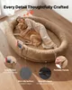 A woman and a dog are sleeping on a large oval dog bed. Produktbild-Vorschau
