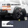 A person is working on the wheel of a white truck, which is parked on a textured black floor. The floor is likely the product being advertised. Voir les images du produit