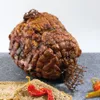 A smoked meat product, possibly ham or sausage, is presented on a dark surface with slices of bread and chili peppers. Podgląd zdjęcia produktu