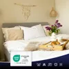 A neatly made bed with pillows, a tray with breakfast items, and a vase of flowers. Produktbild-Vorschau