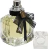 Flakon mit goldgelbem Parfum, YSL-Emblem an schwarzer Schleife, silberner Düse und eckiger, transparenter Verschlusskappe im Vordergrund. Produktbild-Vorschau