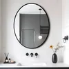 A modern bathroom vanity area with a large oval mirror above a sink. Podgląd zdjęcia produktu