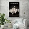 A poster of Billie Eilish is displayed on a wall in a room with a couch and a plant. Náhled obrázku produktu