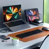 A desk setup with a laptop, tablet, phone, keyboard, mouse, and charging station. Podgląd zdjęcia produktu