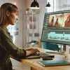 A woman is editing a video on a computer in an office setting. Voir les images du produit