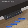 A close-up of a black control panel for a standing desk, mounted under a dark desktop. Náhled obrázku produktu