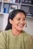 A woman wearing a headset smiles while looking to the side, suggesting she is on a call. Anteprima dell’immagine prodotto