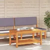 A wooden coffee table with a book and two cups on it, placed in front of a wooden bench with gray cushions, on a patio. Podgląd zdjęcia produktu