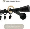 Close-up of a black curtain rod with rings and clips, featuring text overlays about its diameter and stability. Produktbild-Vorschau