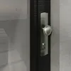 Close-up of a door handle and lock mechanism on a dark wooden door, with a concrete wall in the background. Produktbild-Vorschau