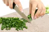 Hands chopping green onions on a cutting board. Náhľad obrázku produktu