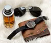 A flat lay of men's accessories including a watch, wallet, sunglasses, and cologne. Produktbild-Vorschau