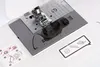 A close-up view of the needle plate and presser foot of a sewing machine, with instructional stickers nearby. Produktbild-Vorschau