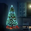 A decorated Christmas tree with presents underneath, in a dimly lit room at night. Produktbild-Vorschau