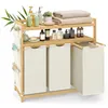 A bamboo laundry hamper with three compartments and shelves for storage, filled with bathroom products and towels. Produktbild-Vorschau