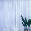 A white curtain with small lights is shown, with a plant in the foreground. Náhled obrázku produktu
