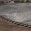 A close-up view of a round, gray shaggy rug on a wooden floor. Anteprima dell’immagine prodotto