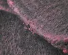 A close-up macro shot of a textured material, possibly fabric or felt, with pink residue or pigment embedded within its fibers. The material appears to be layered, with one piece overlapping another. Anteprima dell’immagine prodotto