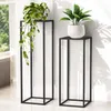 Two black metal plant stands of different heights, each holding a potted plant, are placed indoors near a window. Anteprima dell’immagine prodotto