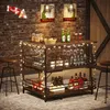 A bar cart filled with bottles and glasses, decorated with fairy lights, set against a brick wall. Náhled obrázku produktu
