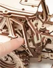 A close-up of a wooden tractor model with a finger pointing to a part of it. Náhled obrázku produktu