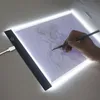 A hand is using a pencil to draw on a light pad. The light pad is illuminated and shows a sketch of a person. Náhled obrázku produktu