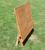 A wooden folding table is shown outdoors on a grassy lawn. Produktbild-Vorschau