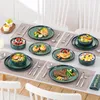 A table setting with multiple plates of food, including a main course, salad, dessert, and breakfast items, arranged on placemats. Voir les images du produit