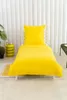 A yellow duvet and pillow set laid out on a white bed frame against a white slatted wall. Podgląd zdjęcia produktu