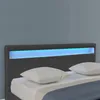 A close-up view of a dark gray upholstered bed frame with a blue LED light strip integrated into the headboard. Two white pillows are placed on the bed. Náhled obrázku produktu