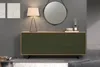 A modern sideboard with a patterned green front and wooden top, shown in a well-lit room setting with a lamp and mirror. Podgląd zdjęcia produktu