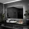 A modern bathroom vanity with a large mirror, sink, and accessories.