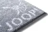 A close-up view of a gray bath mat with a white pattern. Produktbild-Vorschau